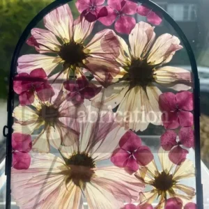 Pressed pink flowers in an arch frame