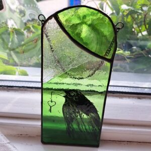Blackbird on green stained glass panel