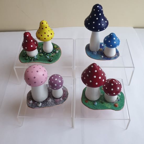 trio of painted wooden mushrooms on an enamelled copper base 