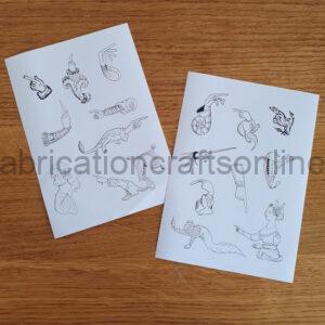 Two white sticker sheets with black line drawn images on them of medieval marginalia and manicules