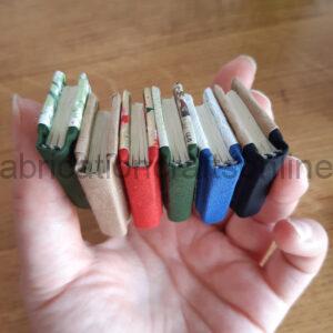 A hand holding a selection of miniature handmade books.