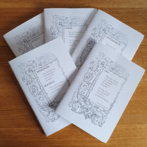 Five white pamphlet notebooks each with the same ornamental frame on but with different quotes from Shakespeare's first folio.