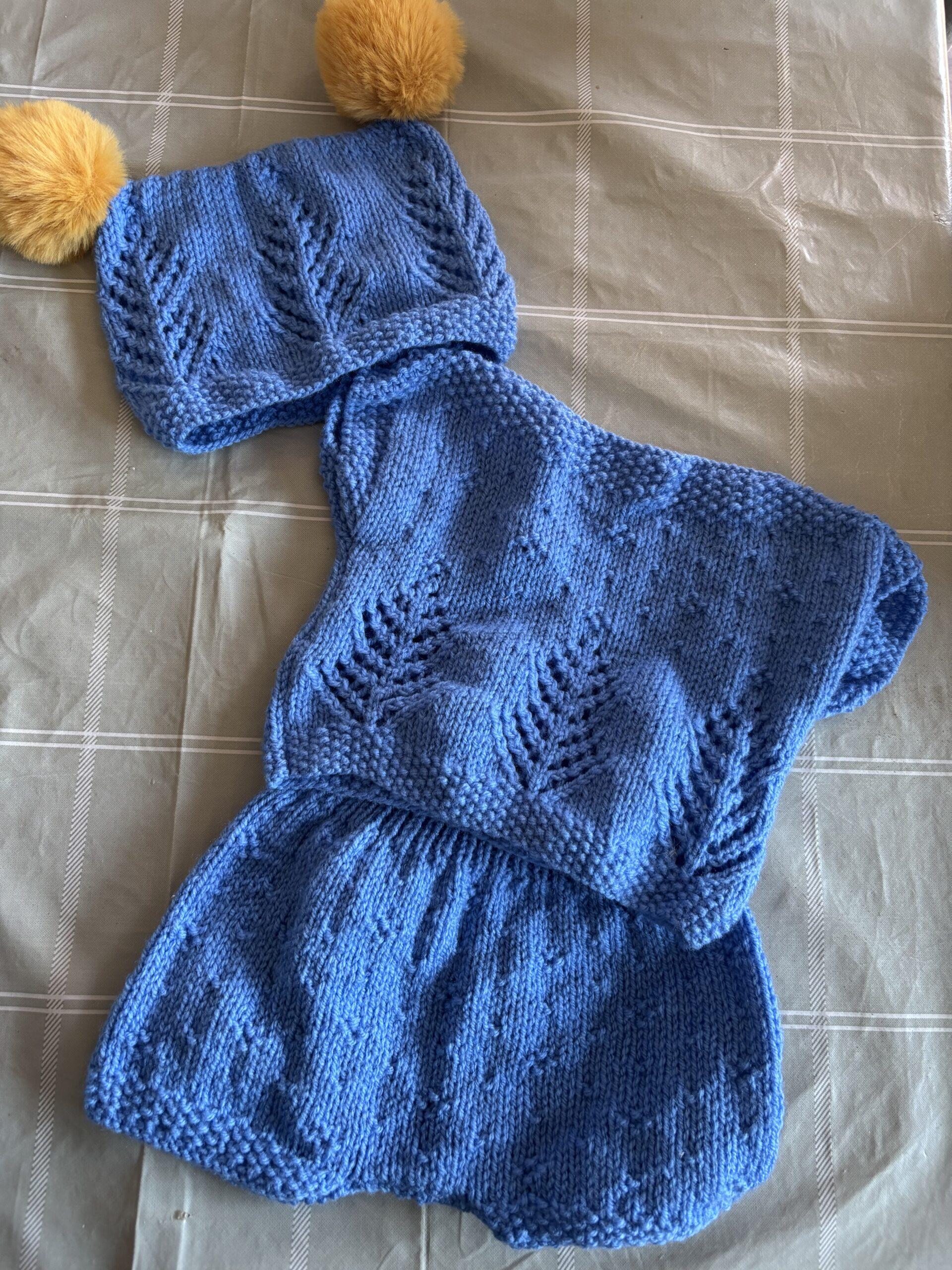 a hand knitted baby grow set includes a hat a baby grown and mittens or bootees 