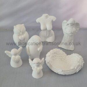 Set of white plaster figurines including angels and cherubs with a heart-shaped basket on a light surface, watermark visible across the image.