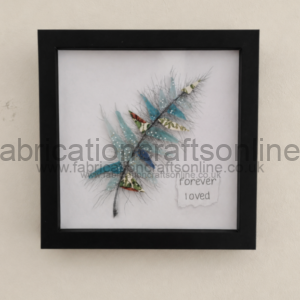 Framed craft artwork with blue feather branches and the words 'forever loved'.