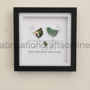 Framed mixed-media artwork of three bird figures made from metal shapes and wire, with the caption 'and then there were three...'