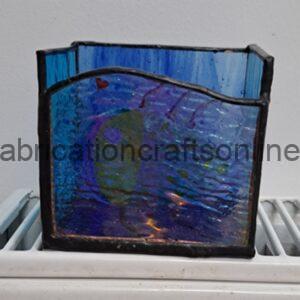 Small blue stained-glass panel with a wavy top edge and a red heart sticker, resting on a white radiator.