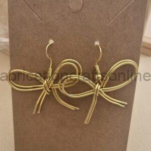 Gold-tone wire bow earrings attached to a brown display card with two hooks at the top edge.