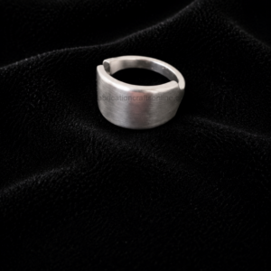 Wide silver ring with a gap, resting on black velvet fabric. (informative)