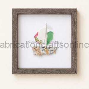 Textile art framed in a dark wood square frame: a small sailboat collage on white background built from fabric scraps and rope pieces.