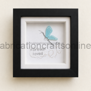 Framed artwork with a blue butterfly perched above the handwritten words ‘Forever I loved’ on white paper.