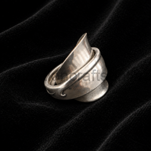 Silver spiral ring resting on black velvet fabric, close-up shot.