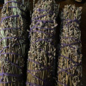 Dried lavender bundles bound with purple twine on a wooden table.