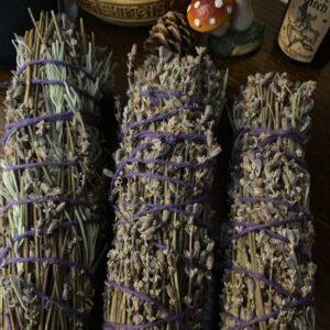 Dried lavender bundles bound with purple twine on a wooden table.