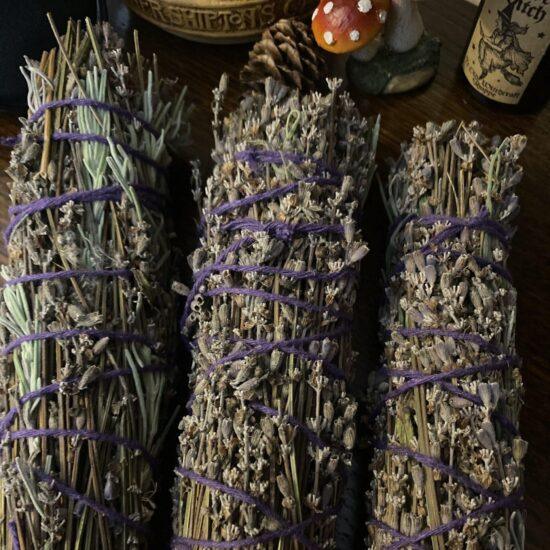 Dried lavender bundles bound with purple twine on a wooden table.
