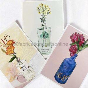 Three decorative art prints depict flowers in glass bottles against pastel backgrounds: yellow blooms in a tall jar, orange blossoms in a white bottle, and pink roses in a blue bottle with '1869'.