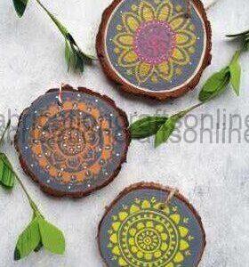 Three round wooden coasters painted with intricate mandala designs on a light background.