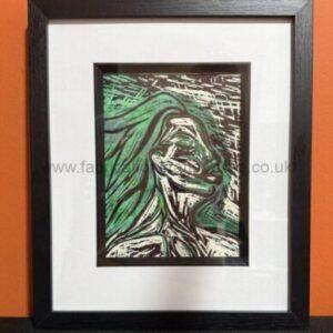 Framed abstract portrait with green hair, head tilted back, black frame and white mat against an orange wall.