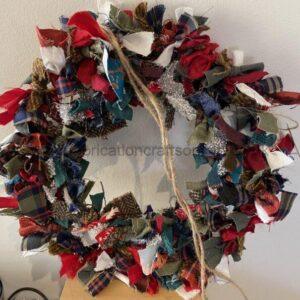 Colorful fabric-scrap wreath decoration hanging on a wall.