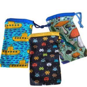Set of three drawstring pouches with playful prints: blue submarine pattern, black space-invader pattern, and green mushroom/ocean pattern, each with colored tops and cords.