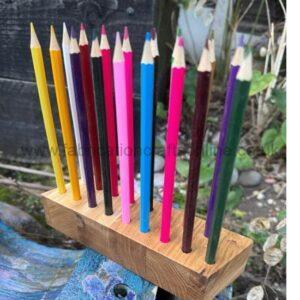 Row of colorful sharpened pencils standing upright in a wooden block