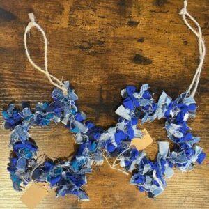Blue denim rag garland laid across a rustic wooden table, tied with natural twine and a small brown tag nearby.
