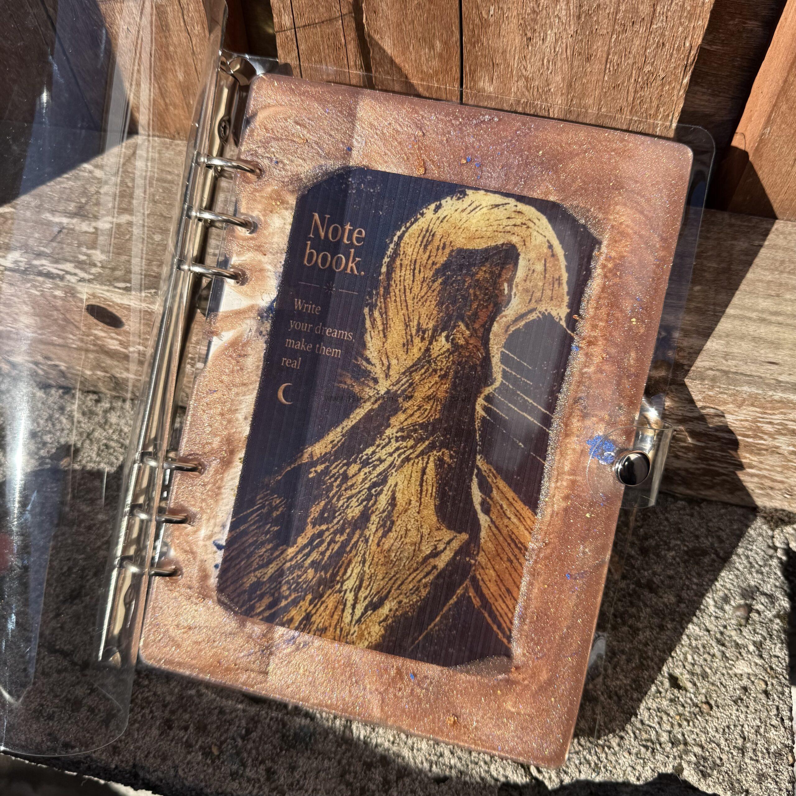img handmade a refillable notebook with an original alova artwork set within a hand poured resin cover warm copper and gold tones with subtle blue details make each piece unique