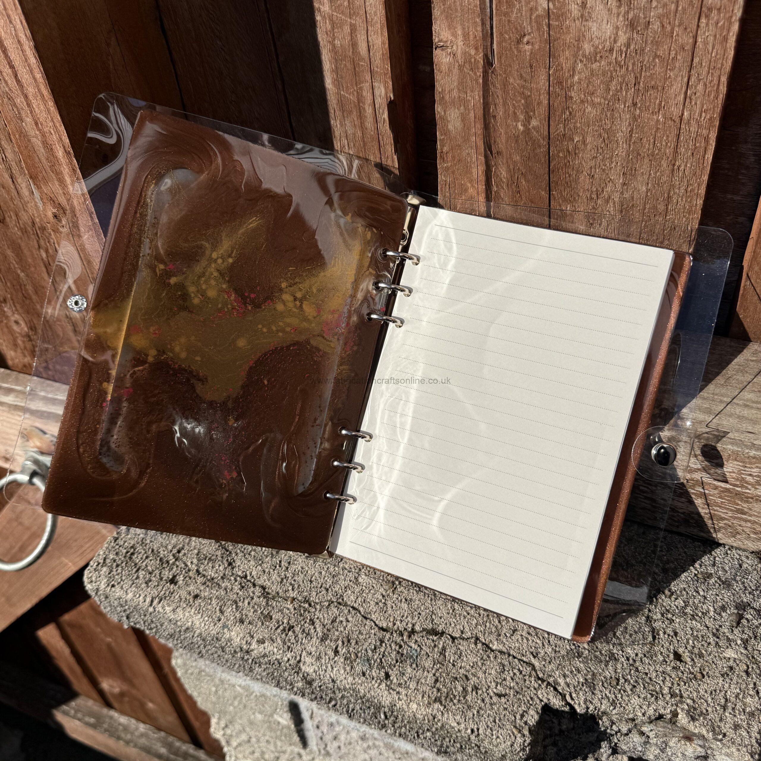 img handmade a refillable notebook featuring an original alova artwork set within a hand poured resin cover in warm copper tones with subtle colour details