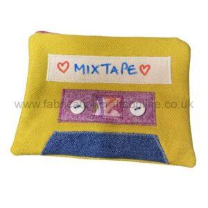 Yellow fabric cassette-shaped pouch with a white 'MIX TAPE' label, purple center, and blue bottom panel.