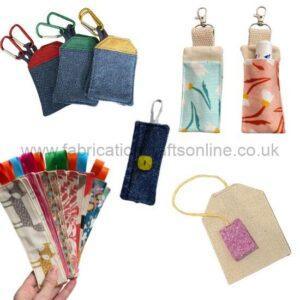 Assorted small fabric pouches and card holders with metal clips in multiple colors and patterns, including denim and florals.