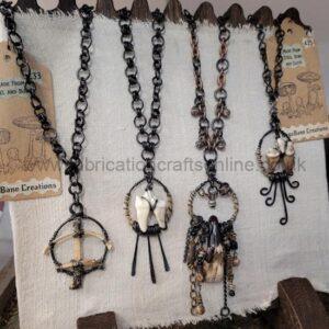 Assorted handmade metal and shell necklaces hanging on a display rack.