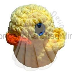 Close-up of a yellow fluffy chick toy with an orange beak and blue eye against a white background.